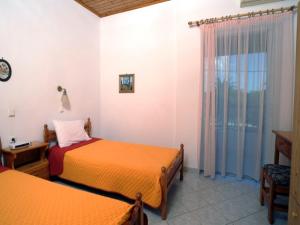 a bedroom with two beds and a window at Ferienhaus Elena in Agios Georgios