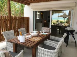 Vila Mare - Praia de Chaves frontline في Cabeçadas: طاولة وكراسي خشبية على الفناء