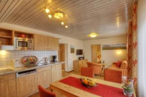 a kitchen and dining room with a table and a kitchen and a room at Pension Fohrenberg in Ewattingen