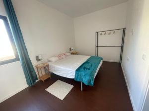 a small bedroom with a bed and a window at Tia Nita Apartamentos in Mindelo