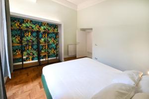 een slaapkamer met een wit bed en een schilderij aan de muur bij St Peter Regal Apartment in Rome