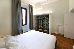 een slaapkamer met een wit bed en een raam bij St Peter Regal Apartment in Rome