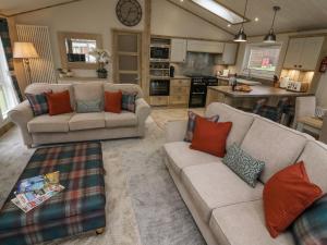 a living room with two couches and a kitchen at Lindale Lodge in Carnforth