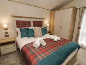 a bedroom with a large bed with towels on it at Lindale Lodge in Carnforth