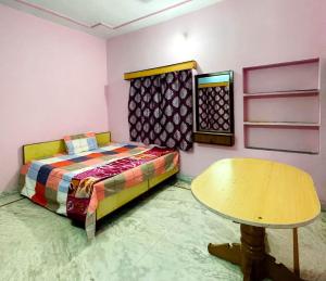 a room with a bed and a table in it at Hotel Marudhar and Restaurant in Pushkar