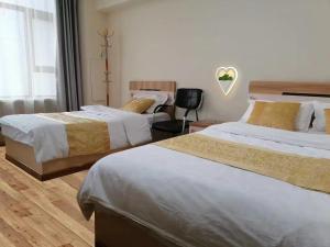 a hotel room with two beds and a window at Xinming Fashion Hotel in Yanji