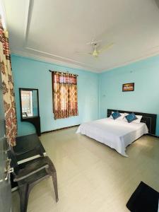 Hotel Marudhar Pushkar في بوشكار: غرفة نوم بسرير وكرسي وجدران زرقاء