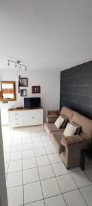 uma sala de estar com um sofá e um piso de azulejo branco em Casa Sandra en Las Norias Todoque con Wi-Fi em Los Llanos de Aridane
