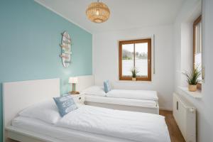 biały pokój z 2 łóżkami i oknem w obiekcie BeachLife-Strandnahe 3 Zimmer Terrassenwohnung w mieście Pelzerhaken