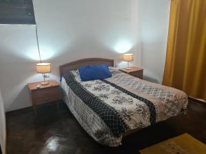 a bedroom with a bed and two lamps on tables at Casa Al pie del Cerro in Yerba Buena