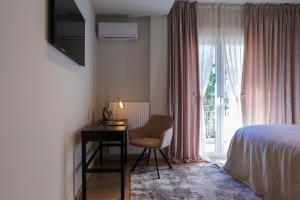 una camera da letto con scrivania, letto e finestra di Acropolis Deluxe 2BR Apartment ad Atene