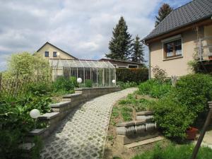 a garden with a stone path and a greenhouse at Ferienwohnung am See 