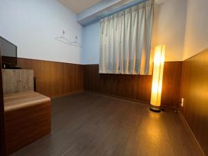 an empty room with a lamp and a window at Hotel Sunplaza 2 in Osaka