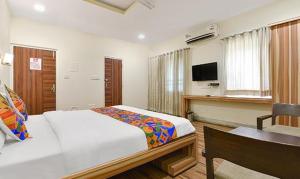 een slaapkamer met een bed, een bureau en een televisie bij FabHotel Royal Icon in Udaipur