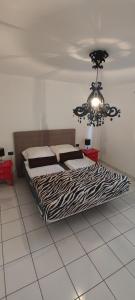 a bedroom with a bed and a chandelier at Casa Sandra en Las Norias Todoque con Wi-Fi in Los Llanos de Aridane