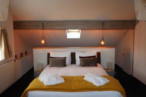 a bedroom with a large bed with towels on it at La Clef D'Or Auberge Communale in Bursinel