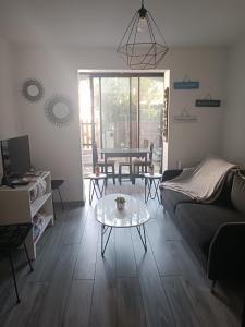 a living room with a couch and a table at Joli studio res au calme en rez de jardin à Bandol. in Bandol