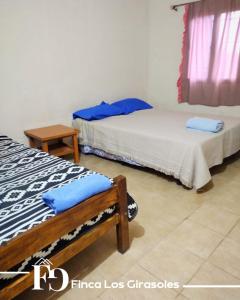 2 camas en una habitación con almohadas azules en Finca Los Girasoles en Salto de las Rosas