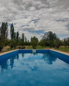 una gran piscina azul bajo un cielo nublado en Finca Los Girasoles en Salto de las Rosas