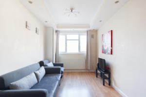 a living room with a couch and a tv at Comfortable Budget Apartment Next To Eurostar International - Kings Cross & Euston Station in London