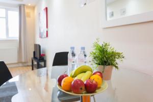 a plate of fruit on a table with bottles of water at Comfortable Budget Apartment Next To Eurostar International - Kings Cross & Euston Station in London