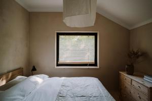 a bedroom with a bed and a window at Gniazdowo nad rzeką - dom z sauną i masażem in Łochów