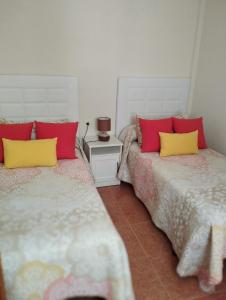 サンタ・クルス・デ・ラ・パルマにあるAVENIDA EL PUENTE SATI 4 Bの赤と黄色の枕が備わる客室内のベッド2台