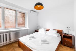 ワルシャワにあるP&O Apartments Tamkaの白いベッドルーム(ベッド1台、窓2つ付)