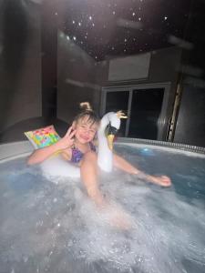 una ragazza seduta in una vasca da bagno con un'anatra di WILLA LAZUR a Łeba