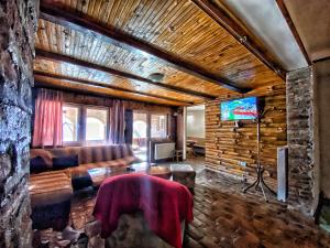 a living room with a couch and a television at Kuca za odmor ,,Balkan” in Crni Vrh