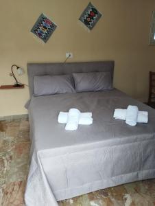 a bed with two white towels on top of it at VALDERICE VACANZE biker's friend in Valderice