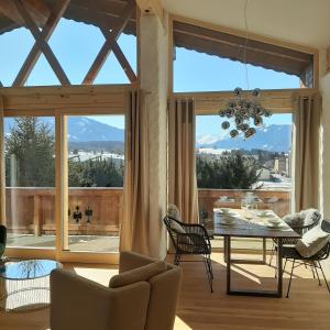 ein Wohnzimmer mit einem Tisch und einem großen Fenster in der Unterkunft Loftwohnung mit Bergblick in Saalfelden am Steinernen Meer