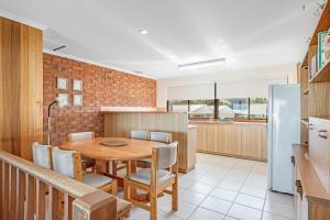 a kitchen and dining room with a table and a refrigerator at Beachfront Views at Southern Sands 1 in Port Elliot
