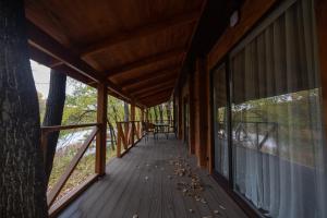 eine überdachte Veranda einer Hütte mit einem Baum in der Unterkunft Lake Park in Nowomoskowsk