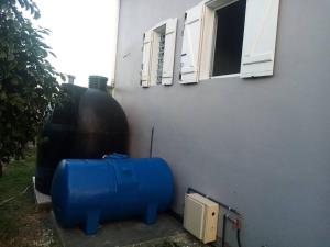 a blue object is sitting next to a building at Studio La Félicité in Le Moule