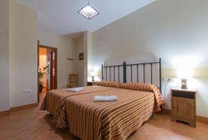 een slaapkamer met een groot bed en 2 handdoeken bij Casa Rural La Fuente in Segura de León