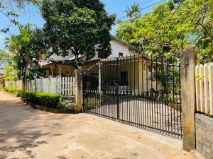 een poort voor een huis met een wit hek bij Unique Villa in Kandy