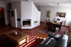 salon z kanapą, stołem i kominkiem w obiekcie Ambiente Chalet Julienhöhe w mieście Niederdorf