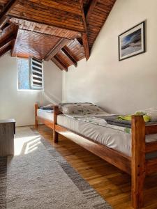 two beds in a room with wooden ceilings at Kuca za odmor ,,Balkan” in Crni Vrh