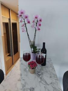 dos copas de vino en un mostrador con un jarrón de flores en Romantic & Lovely flat,near to beach, en Liepāja
