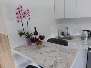 una barra de cocina con dos copas de vino y flores en Romantic & Lovely flat,near to beach, en Liepāja