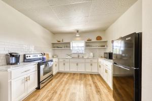 Una cocina con gabinetes blancos y un refrigerador de acero inoxidable. en Riverfront Oasis 2, en Liberty Hill