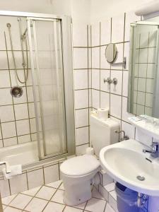 ein Bad mit einem WC, einem Waschbecken und einer Dusche in der Unterkunft Hotel Harlesiel in Harlesiel