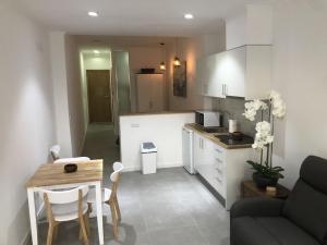 a kitchen and a living room with a couch and a table at Coracão Atlantico Beach House in São Roque