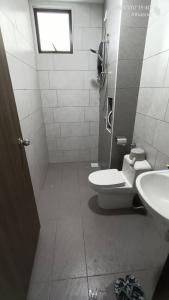 a bathroom with a toilet and a sink and a window at Grand View House GVH in Bandar Penawar