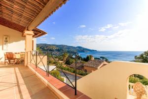 a house with a balcony with a view of the ocean at SELECT'SO HOME - Villa PANORAMA - Services hôteliers & prestations de qualité in Le Lavandou