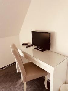 吉夫霍恩的住宿－Zum Deutschen Heinrich，一张白色的桌子,上面有一台电视