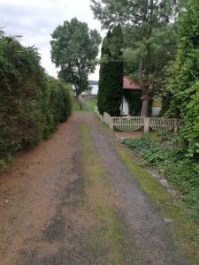 un camino de tierra con una valla y una casa en Pod Sową en Drawsko Pomorskie
