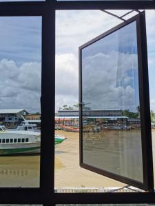 una finestra con vista sul fiume con una barca di MersingFirstFloor丰盛港二楼民宿 a Mersing