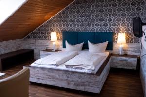 Ein Schlafzimmer mit einem großen Bett, zwei Tischen und zwei Lampen in der Unterkunft Hotel Harlesiel in Harlesiel
